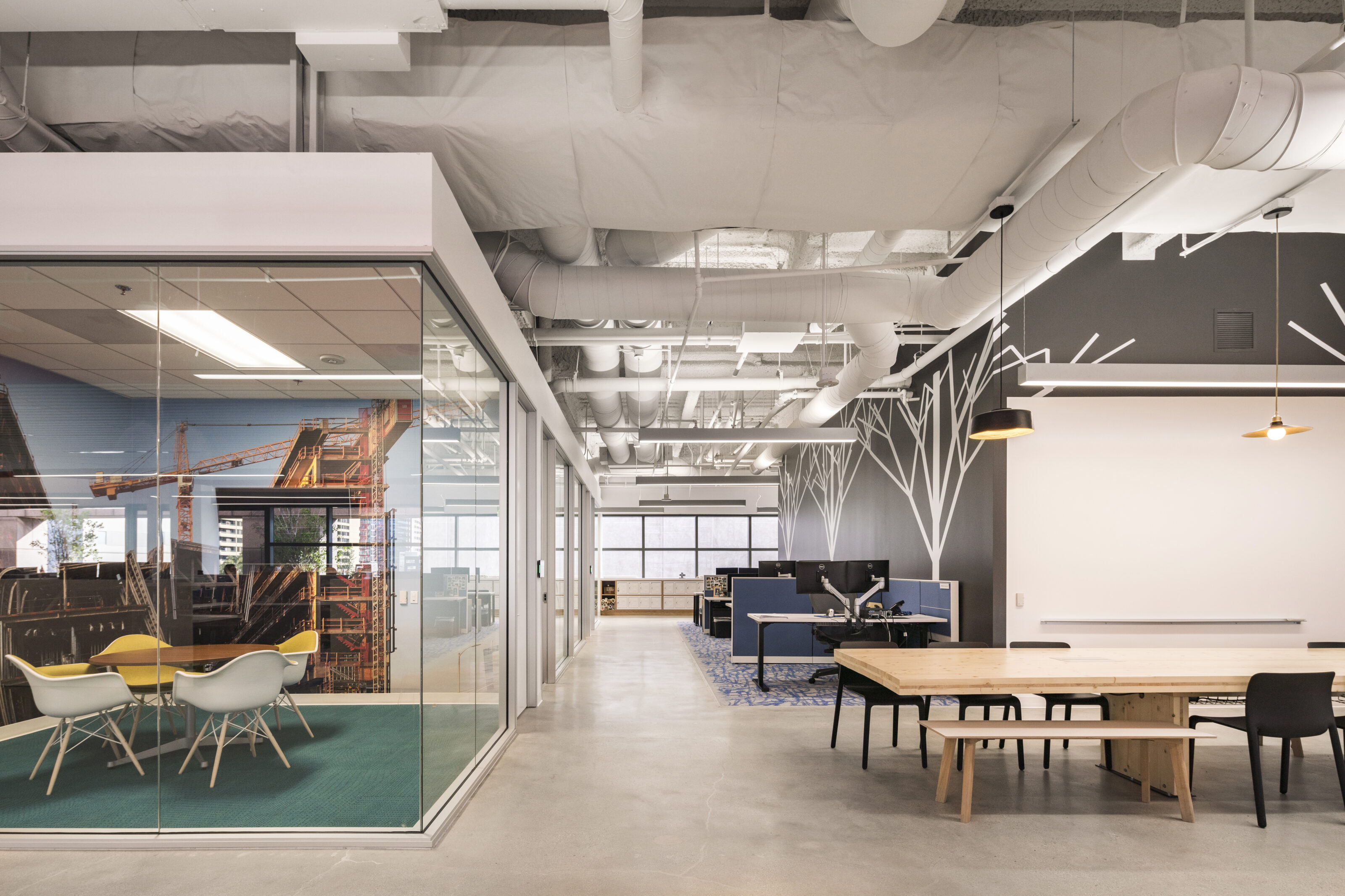 open office space surrounded by glass enclosed office rooms