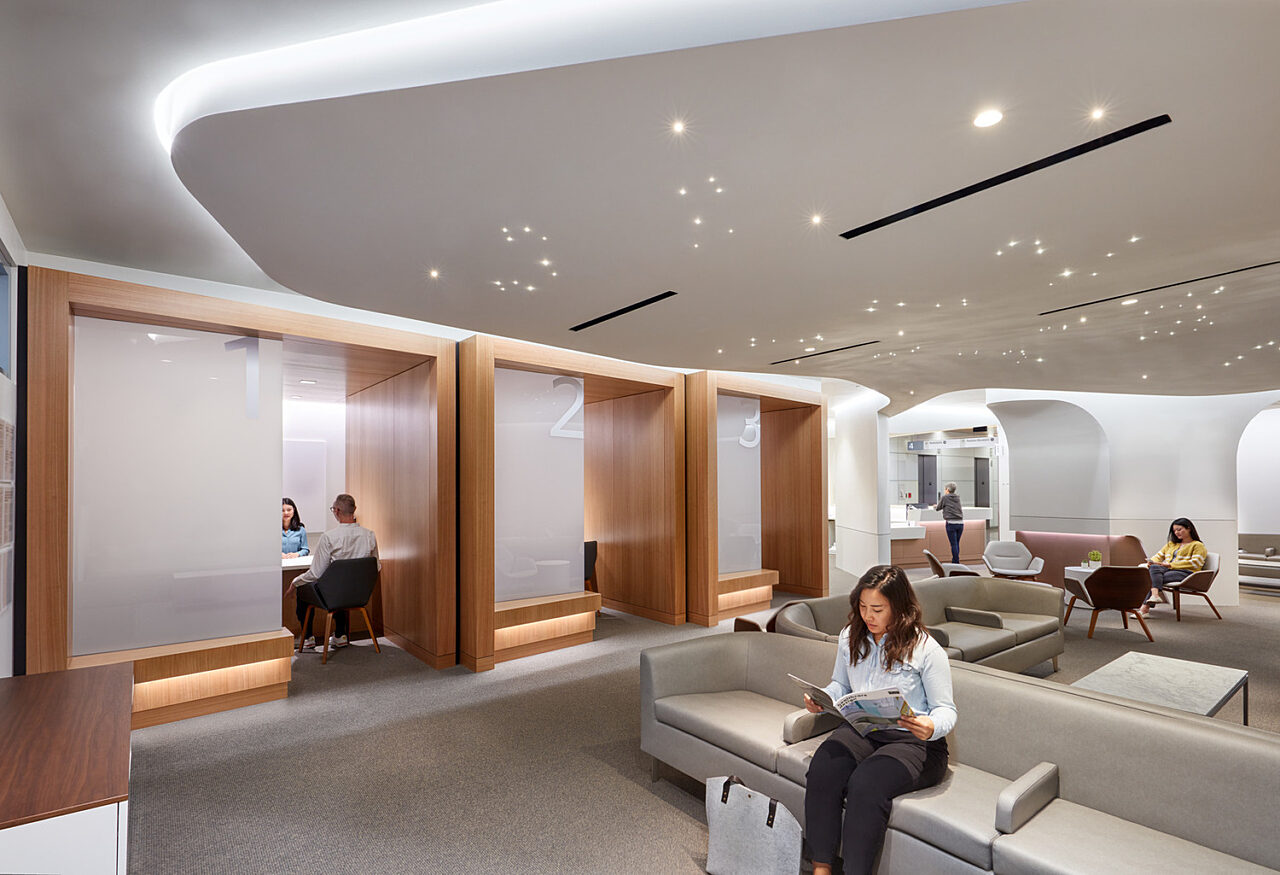 Lady reading a magazine in waiting area of modern lobby