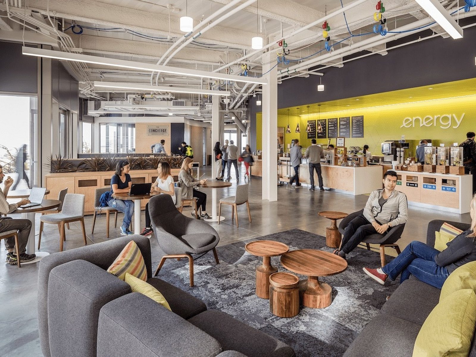 interior office environment with people sitting in communal area working and having conversations with others