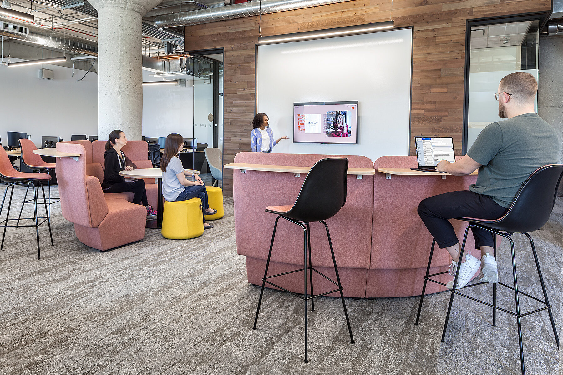 Lady presenting to employees sitting at various workspaces