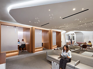 Lady reading a magazine in waiting area of modern lobby