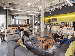 interior office environment with people sitting in communal area working and having conversations with others