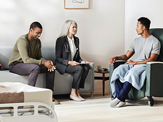 Healthcare office with people sitting on a couch and a chair talking