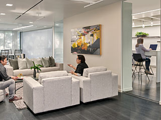Permira office space with people in lounge area working on their computer